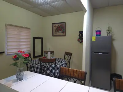 a kitchen with a table and a refrigerator at Beautiful and comfortable house in Sonsonate