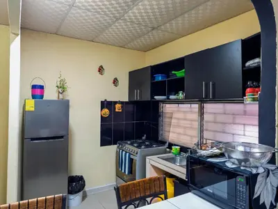 a kitchen with black cabinets and a stainless steel refrigerator at Beautiful and comfortable house in Sonsonate