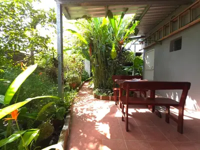 a patio with a wooden bench and a table at Beautiful and comfortable house in Sonsonate