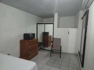 a bedroom with a bed and a mirror and a dresser at Hotel Ohana in San Juan Talpa