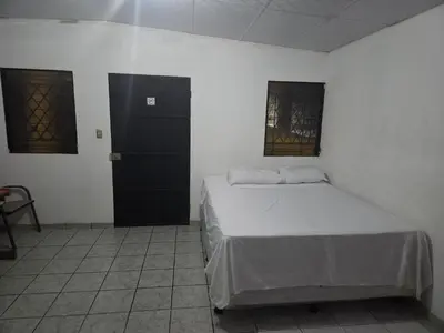 a bedroom with a bed and a black door at Hotel Ohana in San Juan Talpa