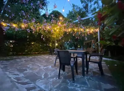 a patio with a table and chairs and lights at Termales El Paraíso in Turín