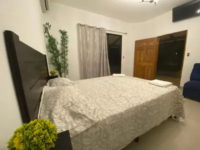 a bedroom with a bed and a blue chair at Termales El Paraíso in Turín