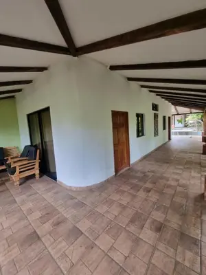 a large room with a white wall and wooden ceiling at Termales El Paraíso in Turín