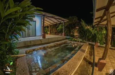 a swimming pool in front of a house at night at Termales El Paraíso in Turín