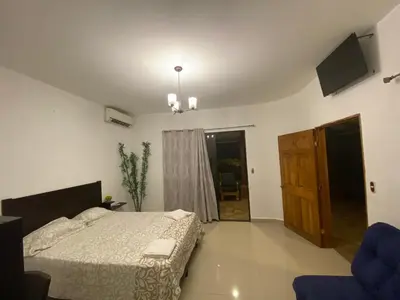 a bedroom with a bed and a tv on the wall at Termales El Paraíso in Turín