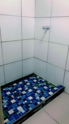 a small shower with blue and white tiles on the floor at Noche de Luna in San Salvador