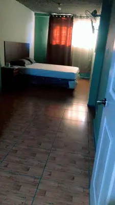 a bedroom with a bed in a room with a wooden floor at Noche de Luna in San Salvador