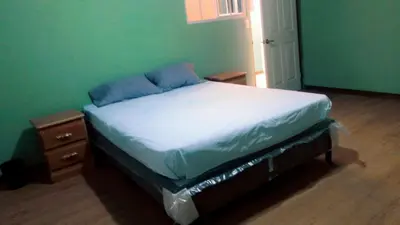a bed in a green room with a nightstand and a bed sidx sidx sidx at Noche de Luna in San Salvador