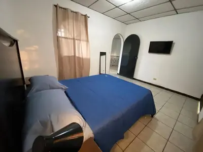 a bedroom with a blue bed in a room at La Casa de Lourdes in Colón