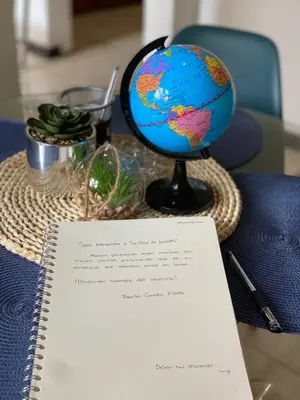 a table with a globe and a notebook on it at La Casa de Lourdes in Colón