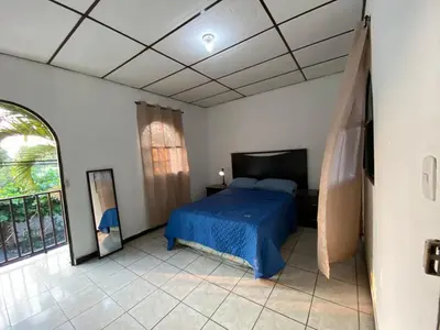 a bedroom with a blue bed and a window at La Casa de Lourdes in Colón