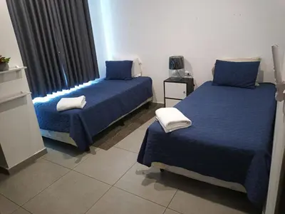 a bedroom with two beds with blue sheets and a window at Apartamento centrico con vista exepcional al volcan de San Salvador in San Salvador
