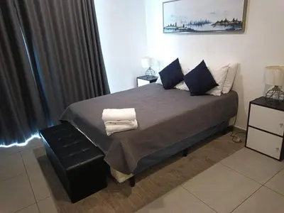 a bedroom with a large bed with blue pillows at Apartamento centrico con vista exepcional al volcan de San Salvador in San Salvador