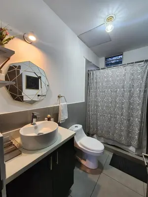 a bathroom with a sink and a toilet at Apartamento centrico con vista exepcional al volcan de San Salvador in San Salvador