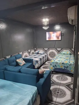 a room with three beds and a tv and a couch at Alquileres El Ángel in San Salvador