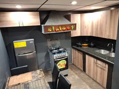 a small kitchen with a stove and a sink at Alquileres El Ángel in San Salvador