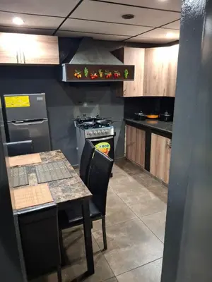 a kitchen with a stove and a table with chairs at Alquileres El Ángel in San Salvador