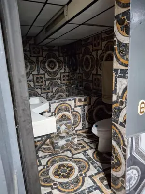 a bathroom with a toilet and a mosaic wall at Alquileres El Ángel in San Salvador