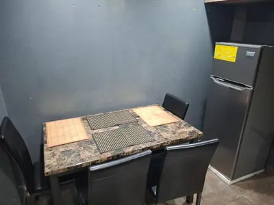 a kitchen with a table with chairs and a refrigerator at Alquileres El Ángel in San Salvador