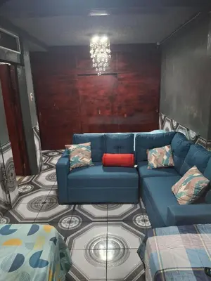 a living room with a blue couch with a red pillow at Alquileres El Ángel in San Salvador