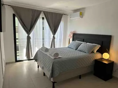 a bedroom with a large bed and a large window at Beautiful apartment near Salvador del Mundo in San Salvador