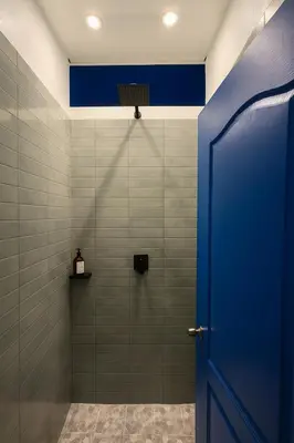 a bathroom with a shower with a blue door at The Duck Dive El Tunco in Tamanique