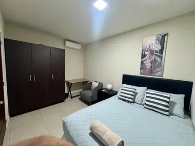 a bedroom with a bed and a chair in it at Moderno, acogedor y privado, en San Salvador in San Salvador