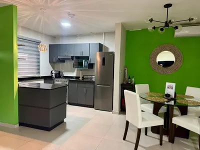 a kitchen with a table and a green wall at Moderno, acogedor y privado, en San Salvador in San Salvador