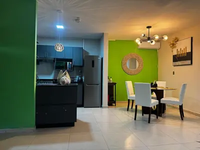 a kitchen with green walls and a table and chairs at Moderno, acogedor y privado, en San Salvador in San Salvador