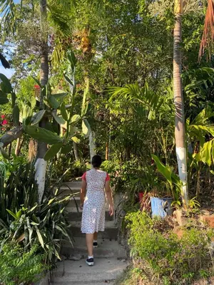 a woman walking down a path in a garden at Aguiñada's house en el Rosario La Paz in El Rosario
