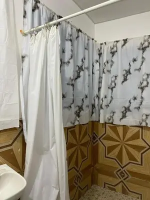 a bathroom with a shower curtain and a toilet at Aguiñada's house en el Rosario La Paz in El Rosario