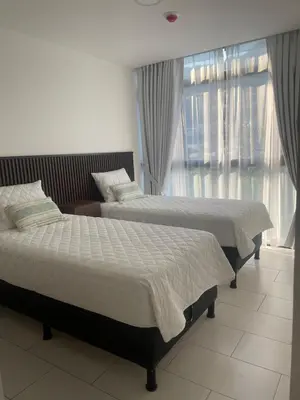 two beds in a bedroom with a window at Cozy apartment with panoramic view in San Salvador