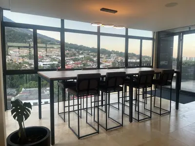 a kitchen with a bar with chairs and a large window at Cozy apartment with panoramic view in San Salvador