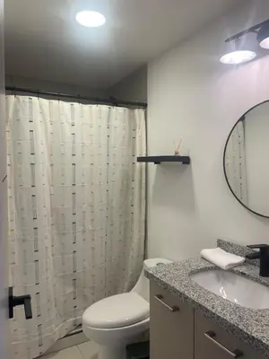 a bathroom with a toilet and a sink and a mirror at Cozy apartment with panoramic view in San Salvador