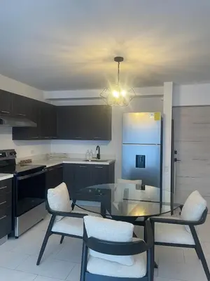 a kitchen with a glass table with chairs and a refrigerator at Cozy apartment with panoramic view in San Salvador