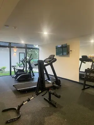a gym with cardio equipment in a room with windows at Cozy apartment with panoramic view in San Salvador