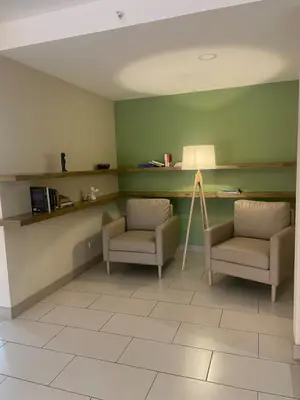 two chairs and a lamp in a room with green walls at Cozy apartment with panoramic view in San Salvador