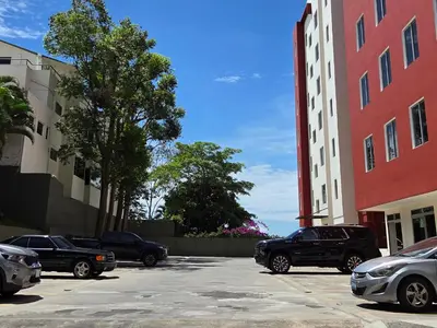 a group of cars parked in a parking lot next to buildings at Habitación en casa de Diana in San Salvador