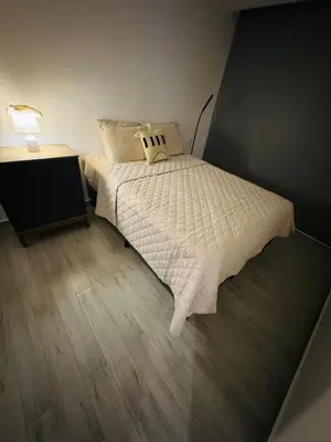 a small bedroom with a bed and a night stand at Beautiful City & Volcano Views in San Salvador