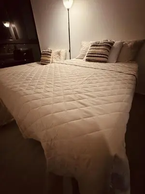 a large white bed in a room with a lamp at Beautiful City & Volcano Views in San Salvador