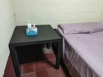 a table with a bottle of soap and a bed at Kame-House Backpackers in San Salvador