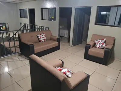 a living room with couches and chairs in a room at Apartamento in San Salvador