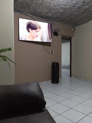 a flat screen tv hanging on a wall in a room at Casa de Huéspedes Noche de Luna in San Salvador