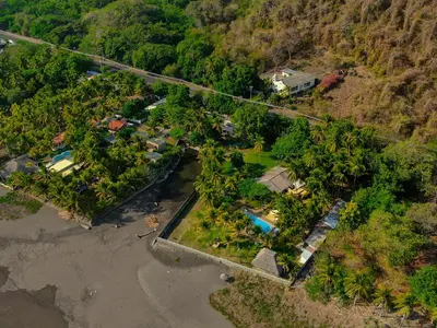 an aerial view of a resort with a road and trees at Mangomar Beach House in Teotepeque