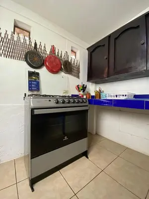 a kitchen with a stove and a counter with utensils at Mangomar Beach House in Teotepeque
