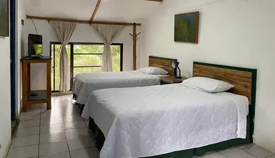a hotel room with two beds and a window at cabañas de Apaneca in Apaneca