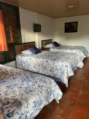 a group of three beds in a room at cabañas de Apaneca in Apaneca