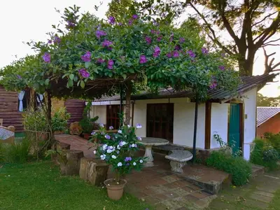 a small house with a bench and flowers at cabañas de Apaneca in Apaneca