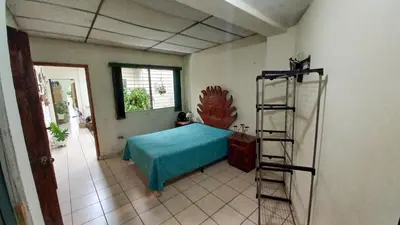 a bedroom with a blue bed and a ladder at Casa Flor Blanca in San Salvador